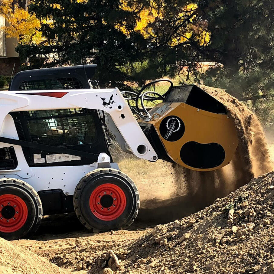 Rock Tools Skid Steer Screening Bucket Attachment screening a pile of dirt.